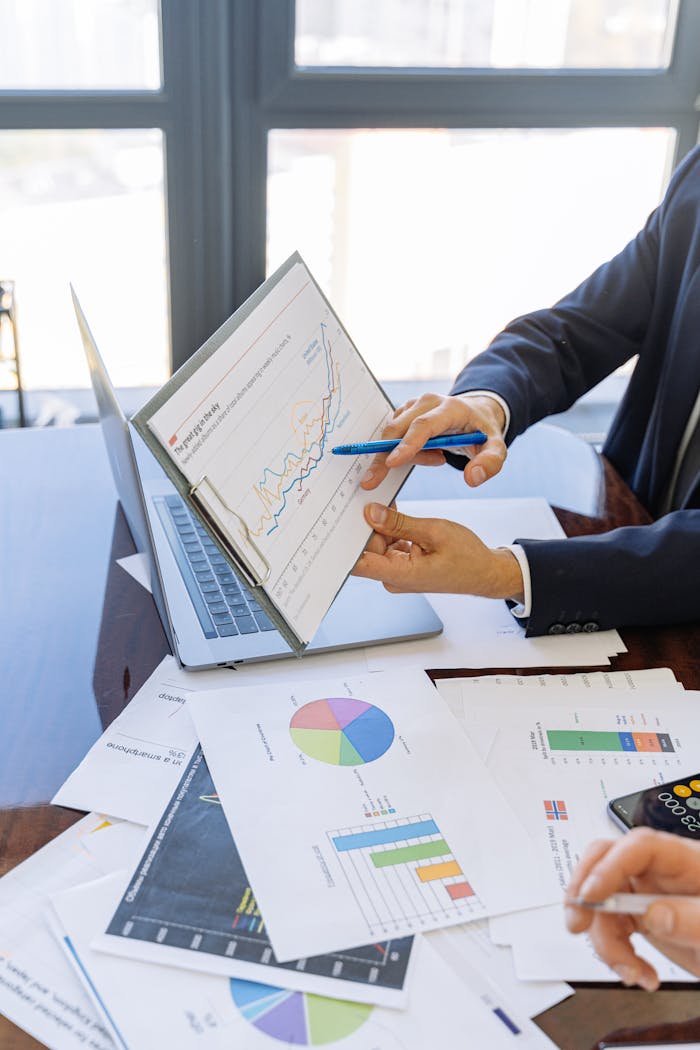 our-experience Business professionals discussing financial graphs and charts in an office setting.