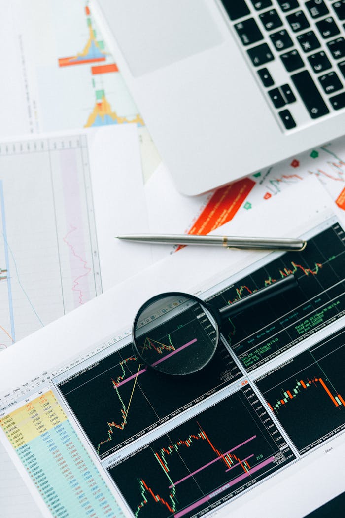 services-img Magnifying glass and graphs depicting stock market data analysis on paper documents.