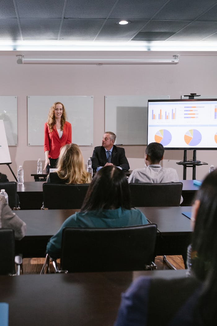 Las 5 habilidades de un Category Manager que de verdad marcan la diferencia A diverse group of professionals attending a conference presentation with charts displayed.