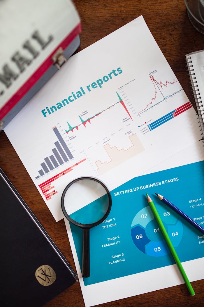 services-02 Financial report with charts and graphs analyzed with a magnifying glass.